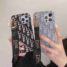 a woman holding two cell phones in her hands with the same phone case attached to them