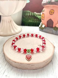 Pink and Red Strawberry Stretch Bracelet - Cottage Core Jewelry  Strawberries remind me of summer. But you can wear this all year round!  This beaded stretch bracelet fits perfectly into the cottage core and coquette aesthetics.   It appeals to so many people!   I think it will be LOVED by anyone who adores: strawberries,  strawberry themed bracelets or strawberry jewelry,  cottage core jewelry,  cottage core bracelets,  coquette bracelets,  coquette jewelry,  girly bracelets,  berry bracelets,  fans of the vintage berry girl with a delicious sounding name...  Pink and red glass crystal beads on strong stretch cord with green crystal beads.  An enamel strawberry charm is attached with a stainless steel jump ring to make the cutest strawberry bracelet! You will receive the item pictured.  A Cute Red Stretch Bracelet For Friendship, Cute Red Beaded Friendship Bracelets, Cute Red Friendship Stretch Bracelet, Cute Red Friendship Bracelets With Round Beads, Red Friendship Bracelets With Round Beads, Casual Red Charm Bracelet Gift, Cute Red Stretch Bracelet Gift, Cute Red Stretch Bracelet As Gift, Red Beaded Charm Bracelet For Friendship