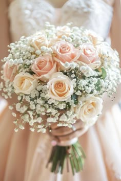 a bridal holding a bouquet of roses and baby's breath