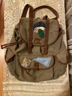 Handmade upcycled one of a kind boho hippie large backpack. Mushroom patch and two additional patches using vintage fabric. Approximately 18 inches long and 16 inches wide. Green canvas with two side pockets and one front pocket. Cordage to cinch the large main area. Top flap with hardware to close up the top of the backpack. Indie Backpack, Patchwork Aesthetic, Patches Backpack, Area Top, Patchwork Backpack, Mushroom Patch, Boho Backpack, Backpack Patches, Boho Deco