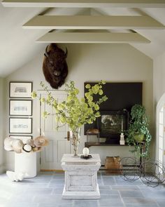 a living room filled with lots of furniture and art on the wall next to a fireplace