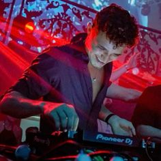 a man that is standing in front of a dj's turntable and mixing