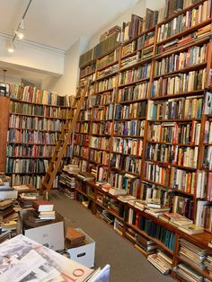 a room filled with lots of books and ladders to the top of each bookcase