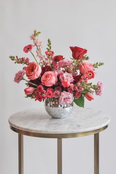 pink and red flower arrangement in a disco mirror ball vase container on a marble and gold table in front of a white background Pink Red Floral Arrangement, Gerber Daisy Floral Arrangements, Bright Pink Floral Arrangements, Pink Red Flower Arrangement, Valentine’s Day Floral Arrangement, Pink And Red Floral Arrangements, Red Pink Flower Arrangements, Pink And Red Flower Arrangements, Red And Pink Flower Arrangements