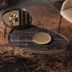 a marble coffee table with two side tables on one end and a gold plate on the other