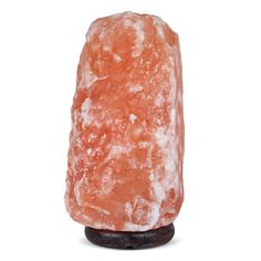 a large orange rock sitting on top of a wooden stand