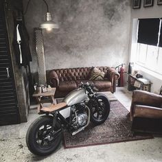 a motorcycle parked in a living room next to a couch