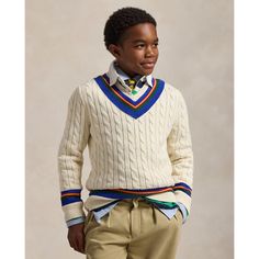 The cricket sweater is defined by its cable-knit pattern usually in cream as well as its V-neck and striped trim which traditionally represents school or club colors. This chunky-knit version is made with combed cotton yarns and washed for enhanced softness.