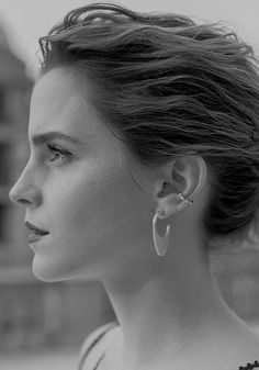 black and white photograph of a woman with ear piercings looking off to the side