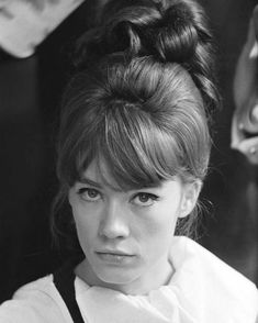 a black and white photo of a woman with her hair in a bun