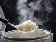 steaming rice in an electric pressure cooker with steam coming from the pot and spoon