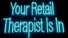 a neon sign that says, your retail therapy is in blue and white letters on it