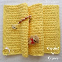 a crocheted book with a teddy bear on the front cover and an attached bead cord