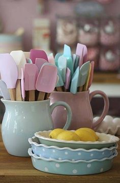 there are many different colored utensils in the cup on the table next to each other