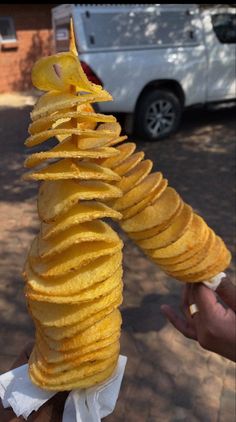 a stack of potato chips sitting on top of a wooden table next to a white car