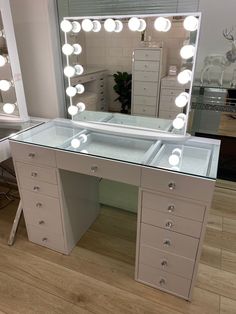 a vanity with lights and drawers in front of a mirror