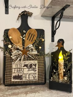 two wooden utensils are sitting next to each other on a shelf in front of a candle