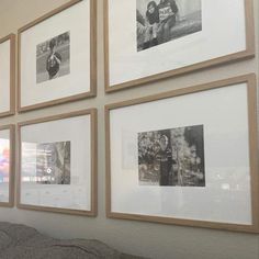 several framed photographs hang on the wall above a bed