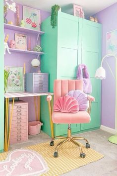 a pink chair sitting in front of a green cabinet next to a desk with drawers