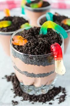 three desserts in small cups with candy on top