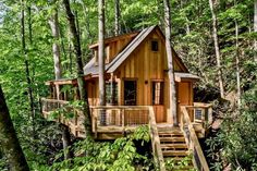 a tree house in the woods with stairs leading up to it