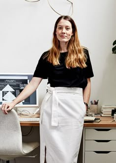 a woman standing in front of a computer desk