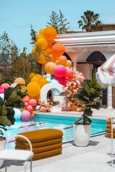 an outdoor pool decorated with balloons, flowers and greenery for a party or celebration