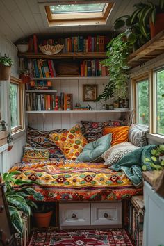 a bed with lots of pillows and blankets in a room filled with bookshelves