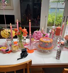 a table is set with flowers and candles for a birthday party or bridal celebration