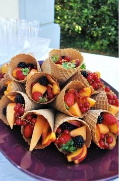 a plate filled with fruit and cones on top of a wooden table