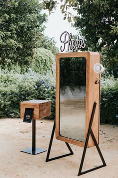 a wooden mirror sitting on top of a metal stand