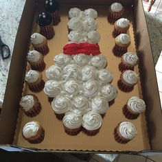 an open box with cupcakes in the shape of a santa clause on it