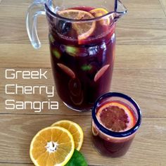 there is a pitcher of sangria next to two glasses with orange slices on the side