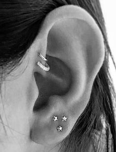 a woman's ear with three small stars on the top and bottom of it