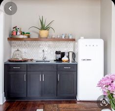 a kitchen with black cabinets and white appliances