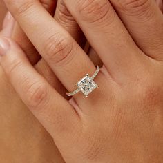 a woman's hand with a diamond ring on top of her finger and an engagement band