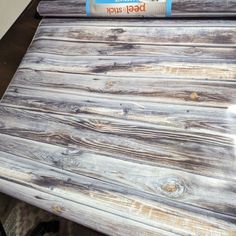 a close up of a wooden table with paint on it and a roll of wood glue