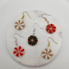 Product Description: This set of earrings is handcrafted with 2mm  seed beads and 4mm faceted beads, featuring unique snowflake and swirl patterns. The classic red, green, gold, and white color scheme combined with the sparkle of faceted beads perfectly captures the festive spirit of Christmas. These earrings add a touch of elegance and charm to your holiday outfits. Material: High-quality 2mm seed beads, 4mm faceted beads, with gold-plated/silver-plated hooks Design: Snowflake and swirl pattern Knit With Beads, Gold And White Color Scheme, Bead Shapes, Holiday Beading, Earrings Patterns, Snowflake Earrings, White Color Scheme, Beading Crafts, Jewelry Tips