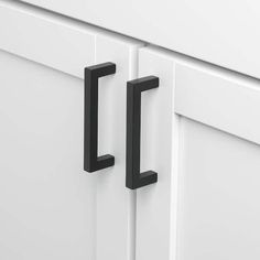 two black handles are on the white cabinet doors