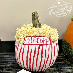 a pumpkin with popcorn in it sitting on top of a table