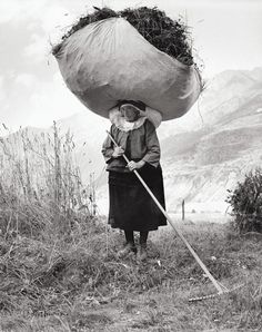 an old black and white photo of a woman with a large bag on her head