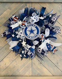 a wreath made out of footballs and stars on a wooden floor with the word dallas written across it