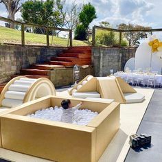 an inflatable hot tub is set up on the ground with tables and chairs around it