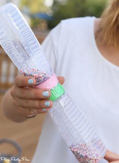 a woman holding a plastic tube with sprinkles on it