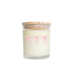 a candle with pink flamingos drawn on the front and bottom in a glass jar