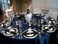 the table is set with black and silver place settings