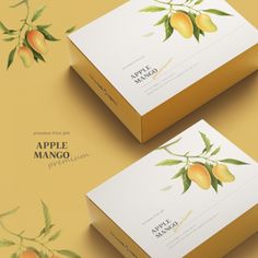 two boxes with mangos on them sitting next to each other in front of a yellow background