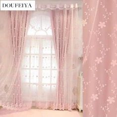 the curtains in this room are pink with white flowers on them and one is open