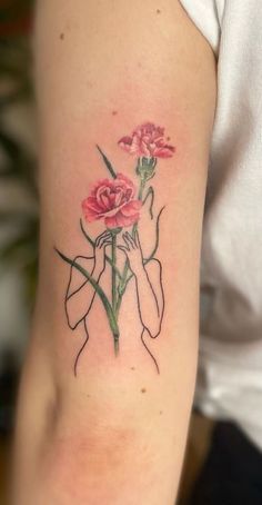 a woman's arm with pink flowers on her left arm and one flower in the middle