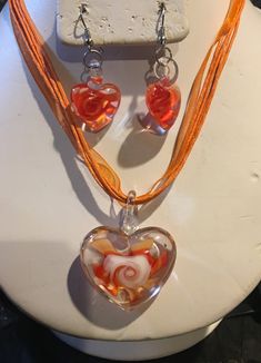 "This cute Orange Murano Lamp Work Glass Heart Pendant Necklace (ribbon chain ) and matching earrings set is appropriate for adults or Kids. It is about 16\" and has an extender also. Please browse through my store, I add items frequently ! Please ask any questions as I do not accept returns Thank You !" Heart-shaped Glass Jewelry For Valentine's Day, Glass Jewelry With Heart Charm For Valentine's Day, Heart-shaped Orange Jewelry For Gift, Orange Heart-shaped Jewelry Gift, Valentine's Day Jewelry With Heart Charm And Glass Material, Valentine's Day Glass Jewelry With Heart Charm, Valentine's Day Clear Glass Jewelry, Adjustable Glass Heart Pendant Jewelry, Orange Heart Beads Jewelry For Gift